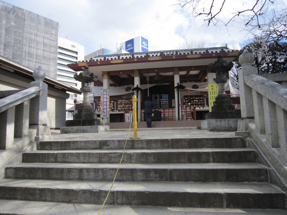 ２石段を登り本堂、お参りしている人。