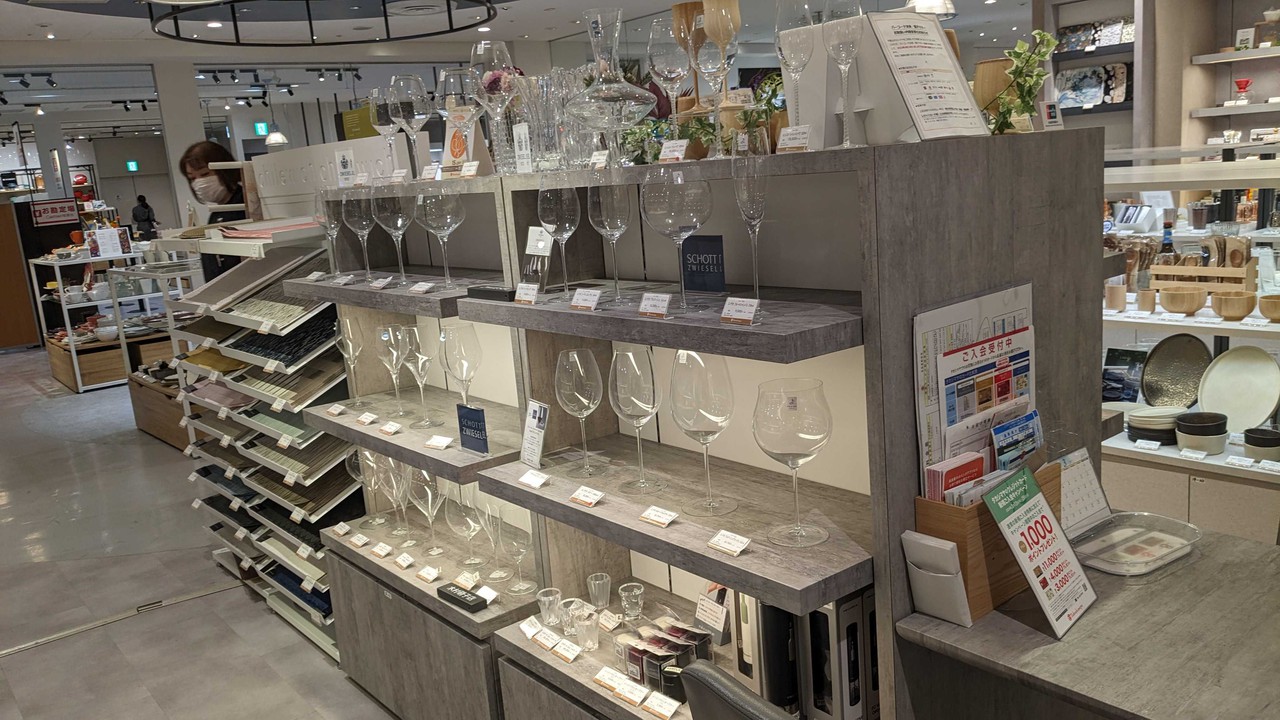 新宿高島屋の和洋食器売り場に並ぶ、ショット・ツヴィーゼルのクリスタルグラスの展示。上質な食器が洗練された空間で魅力的にディスプレイされています。