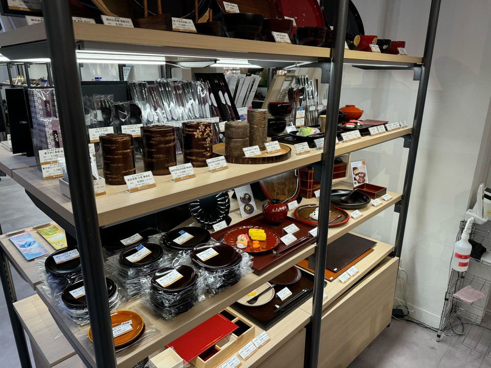 新宿高島屋 和洋食器売り場　棚に工芸品の茶筒やお皿が並んでいる
