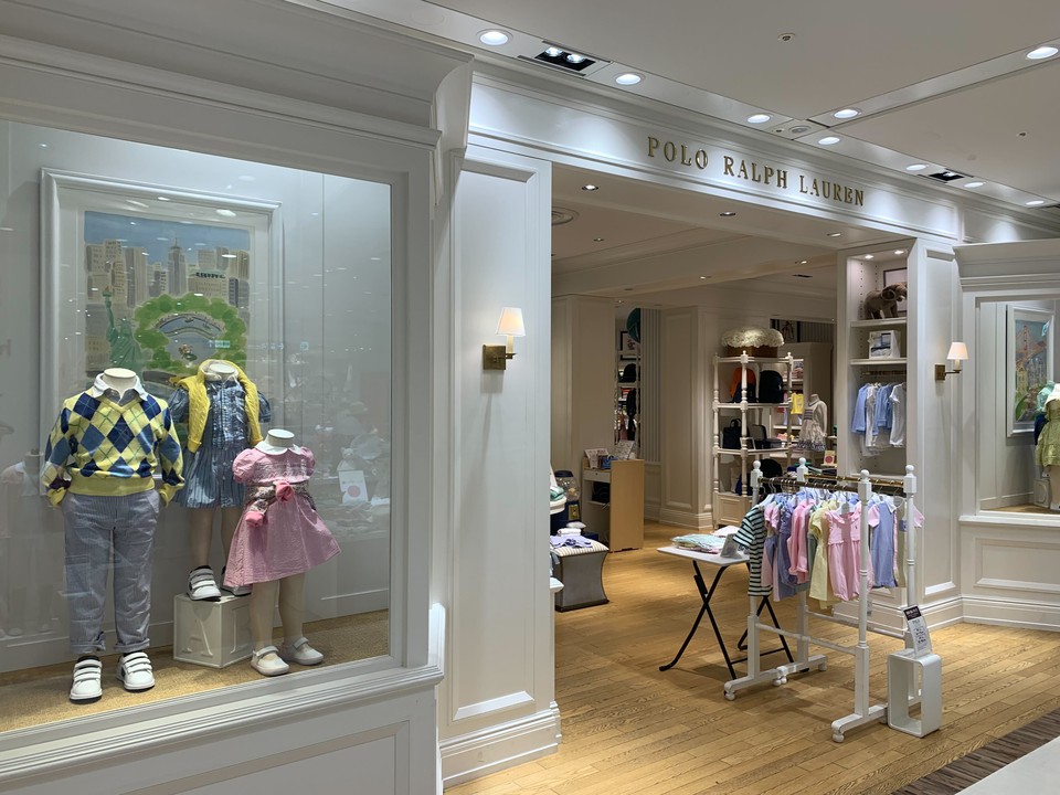 ポロラルフローレンチルドレンの外観に飾られたショーケース。子供服のマネキンがおしゃれな着こなしを提案しています。