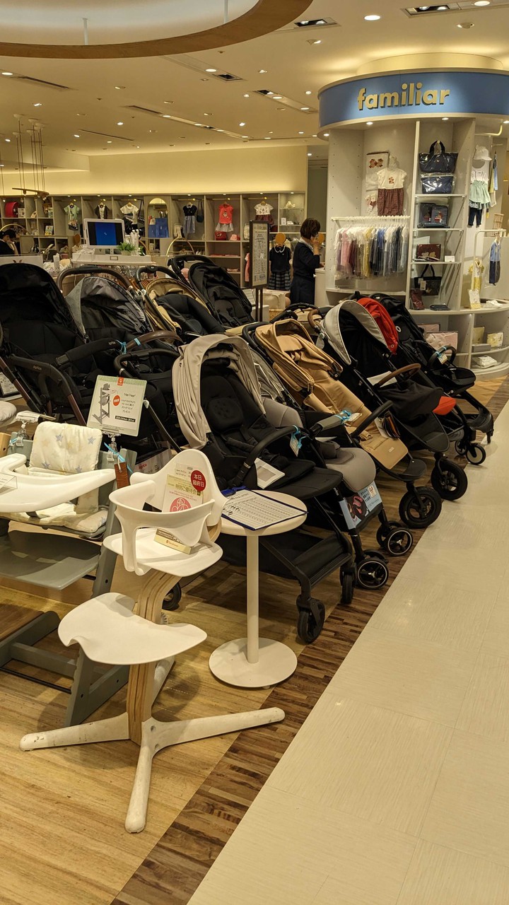 新宿高島屋ハローベビーサロン ベビーカーと子供用の椅子が展示された売り場。背景にはファミリアのコーナーもある。