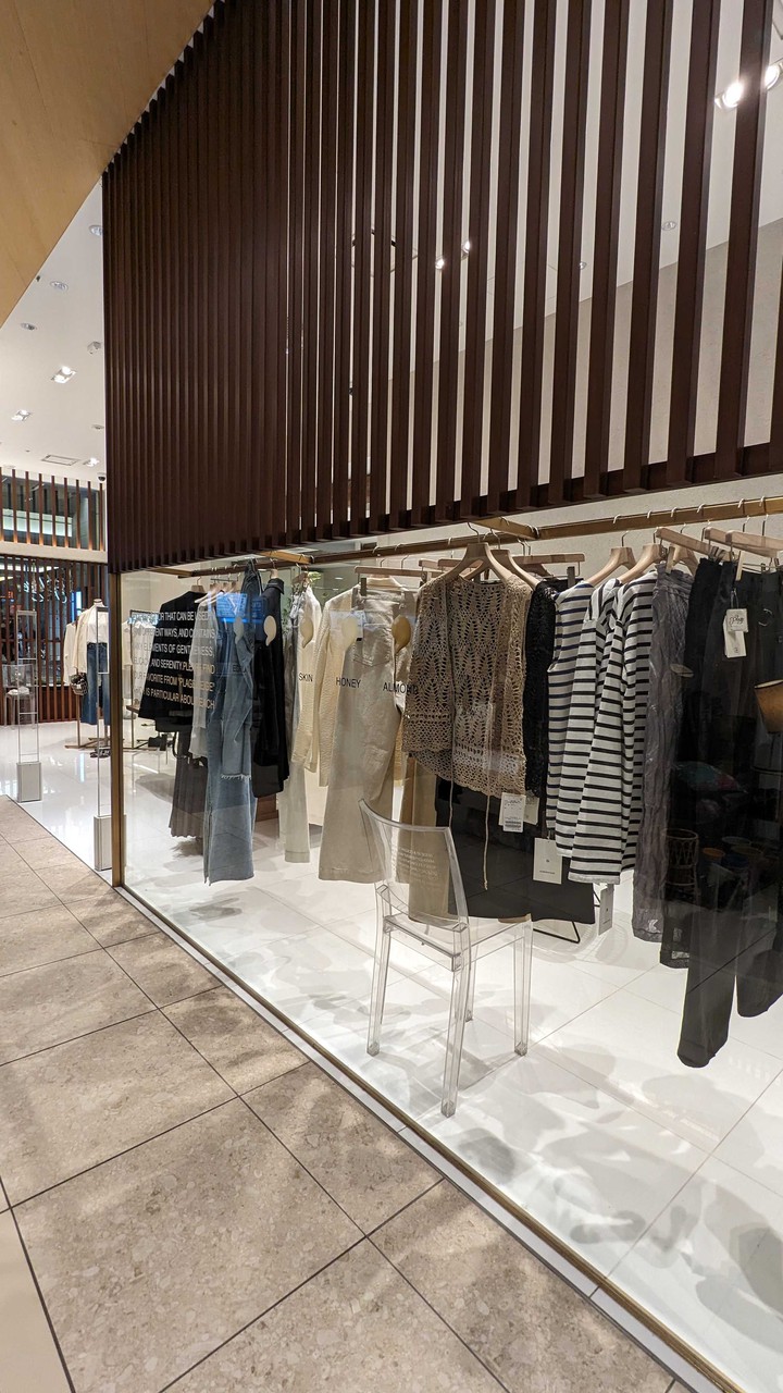 プラージュ店内の衣服と透明な椅子のディスプレイ