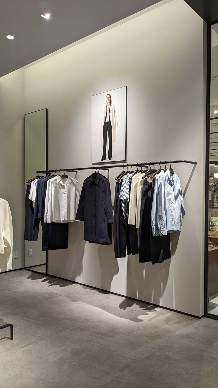 セオリー店内にはモノクロームでスタイリッシュな衣服が展示され、現代的で洗練された雰囲気を醸し出しています。