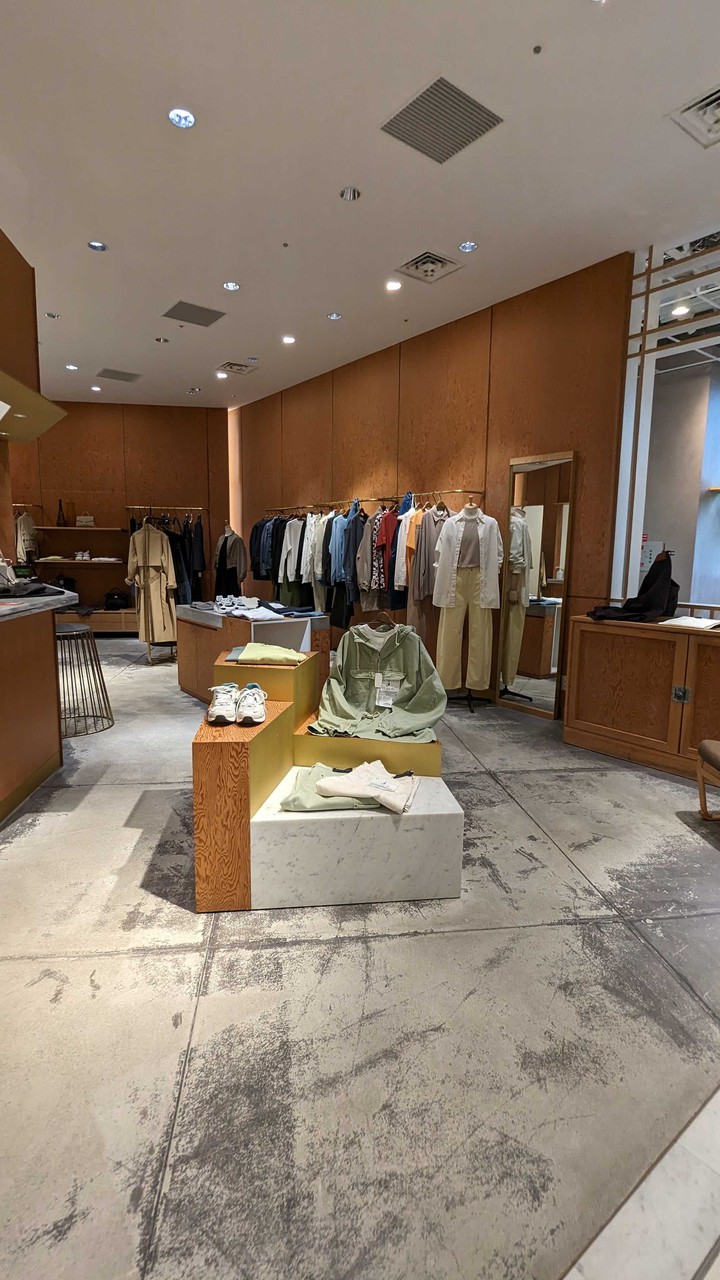 ドローイング ナンバース店内に配置された木製のディスプレイ台と衣類が掛かるラック。
