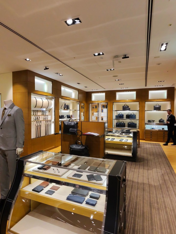DUNHILLの店内全景を示す写真。中央にはガラス張りのディスプレイケースがあり、その周囲にはメンズアクセサリーやバッグが陳列されている
