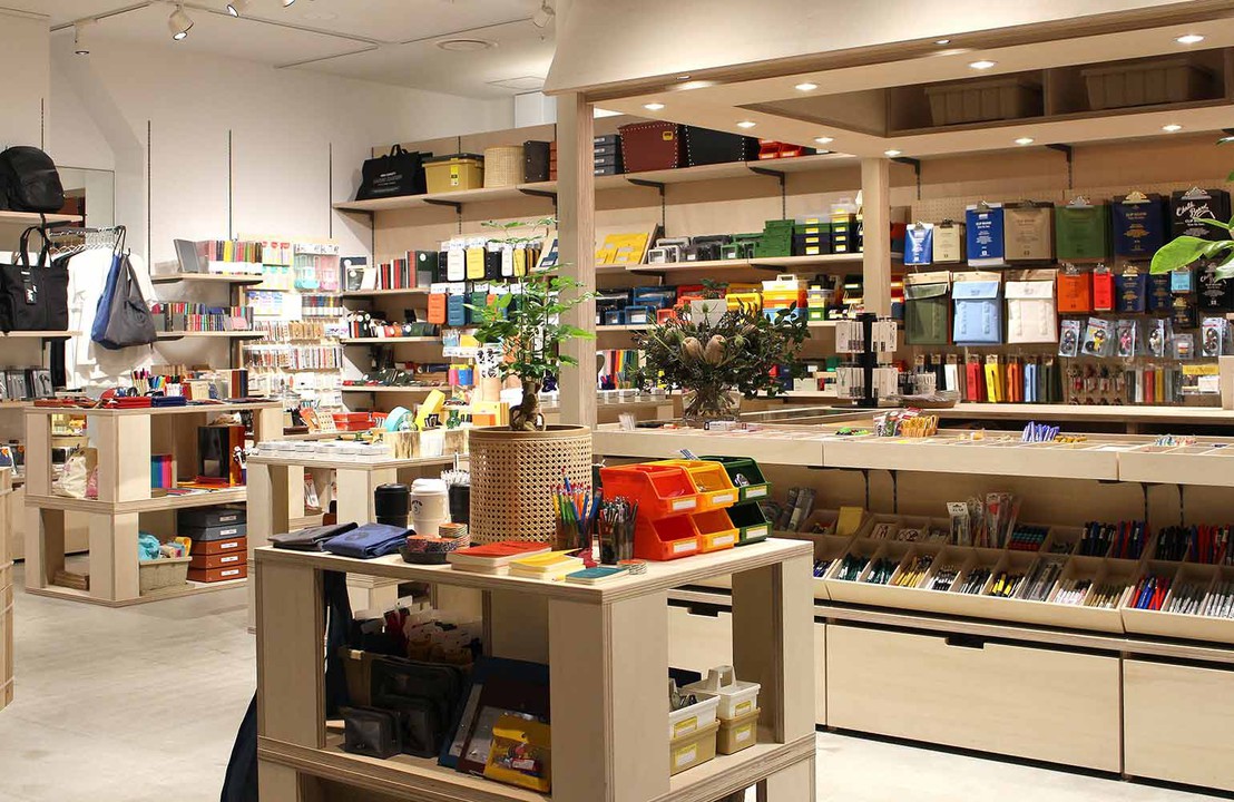 広々とした店内の写真。棚にはさまざまな文房具や雑貨が整然と並んでおり、中央には観葉植物が飾られている