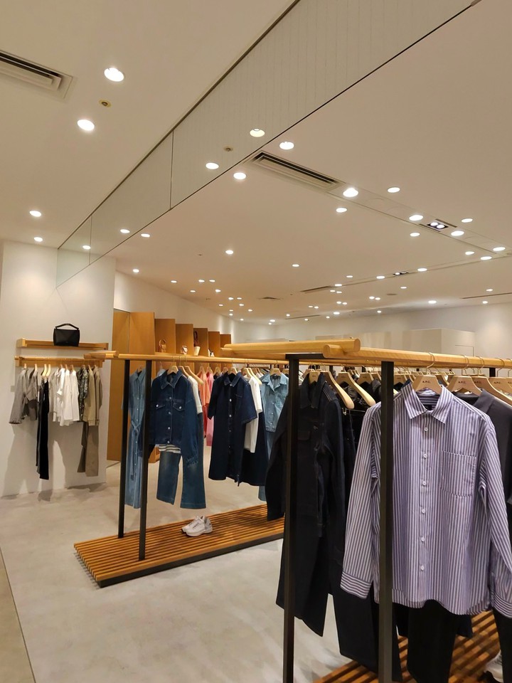 ミニマリストデザインのA.P.C.店内とハンガーに掛かる洋服