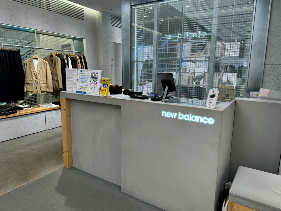 new balanceのロゴが光る店舗のレジカウンター
