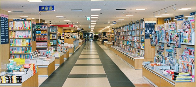  紀伊國屋書店 梅田本店の広々とした通路が写っており、両側に多くの本が陳列されています