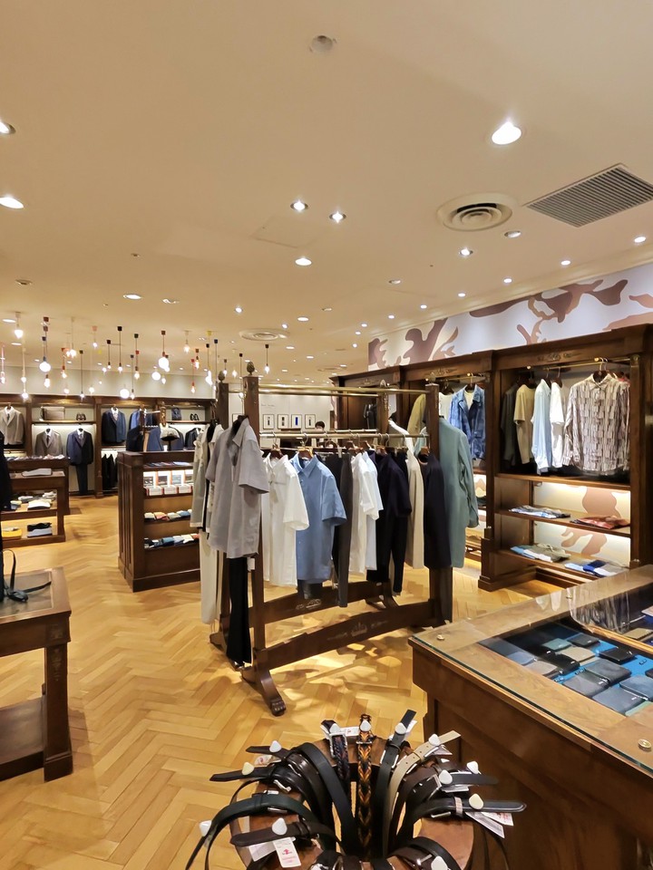 男性もののシャツが並ぶ店内。手前のテーブルにはファッション小物も陳列されている。