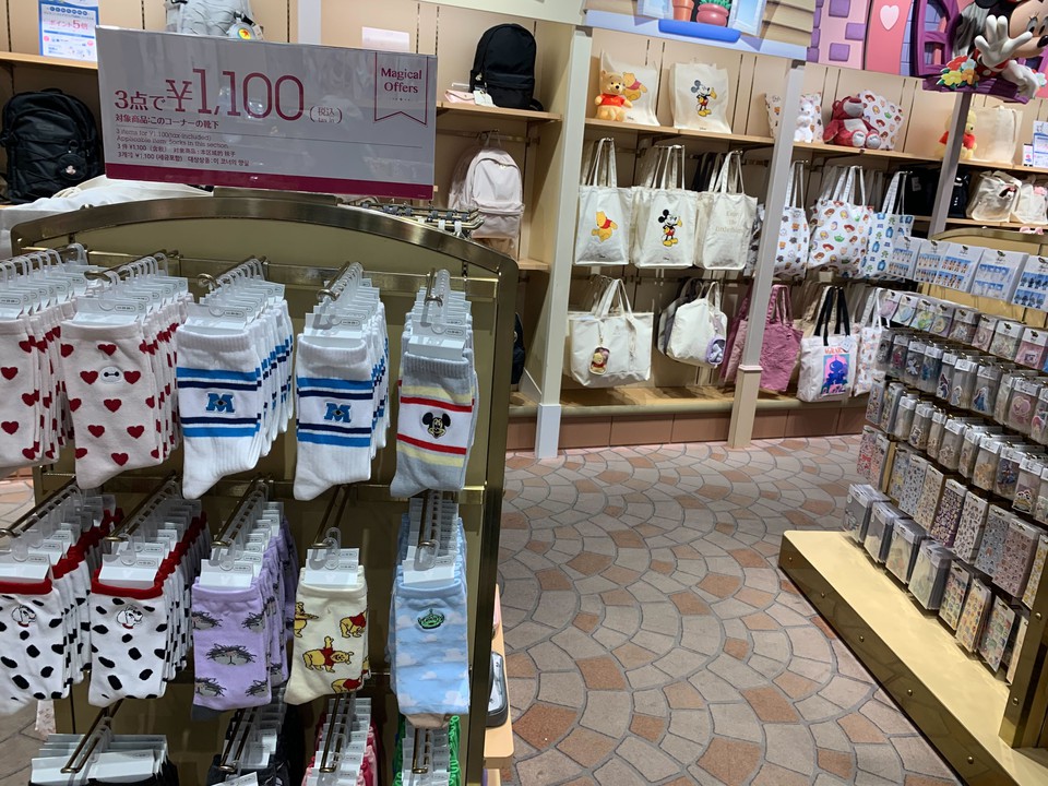 Disney storeでプロモーション看板の下に展示されたディズニーキャラクターの靴下