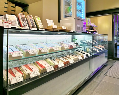 オカシツカサ アンゲツドウの店舗内観。ガラスのショーケースに箱入りの商品が並んでいる。