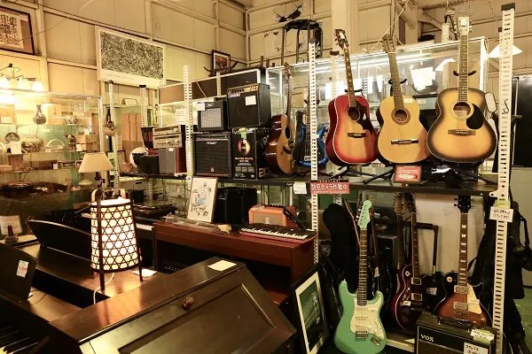 楽器コーナーに並ぶギターやアンプ。照明が当たり、楽器が美しく展示されています