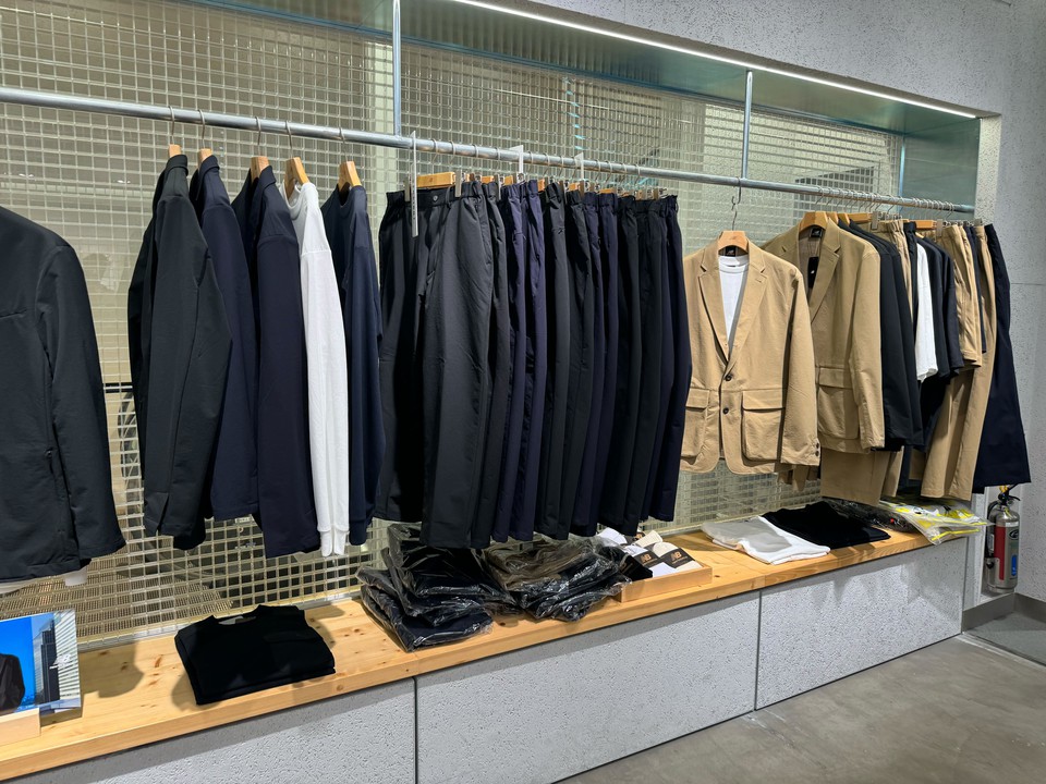 クリーンな店内に吊るされた洋服と置かれたアクセサリー
