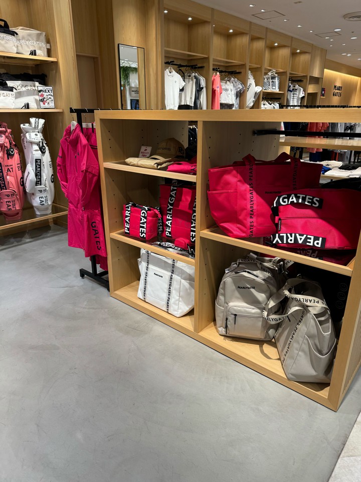 パーリーゲイツの鮮やかなピンクのゴルフバッグが目立つ店内。周囲にはさまざまなゴルフアクセサリーが配置されています。