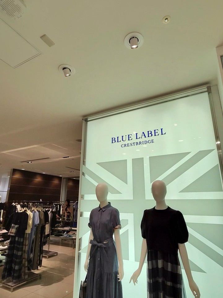 「BLUE LABEL CRESTBRIDGE」の文字が大きく書かれた店頭、濃紺のドレスを着たマネキンが二体立っており、店内には洋服が陳列されている