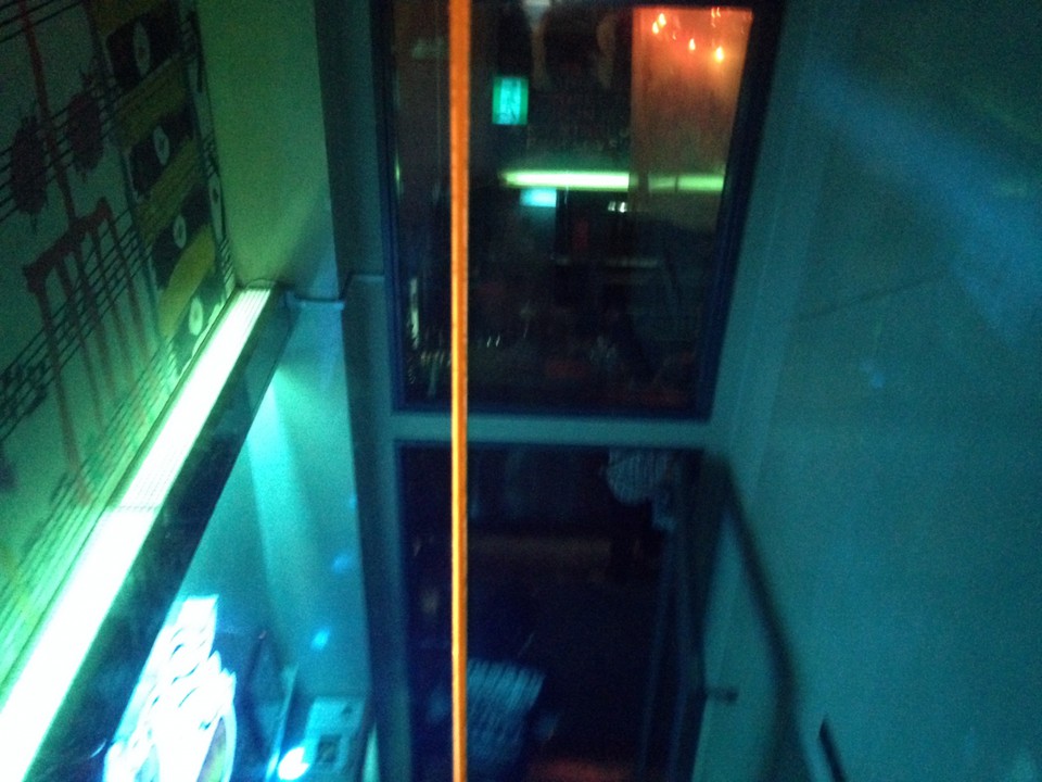 踊り場から会場入り口を見下ろす。（青いのはガラスの色です）