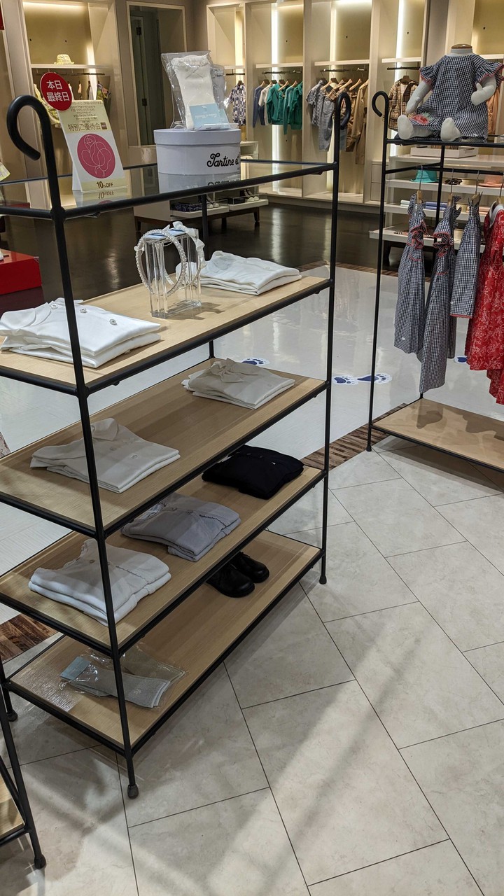 ルティーヌエショコラ店内の棚に並べられた子供服。ポロシャツ、カーディガン、スカートなどのアイテムが綺麗に折り畳まれて展示されており、店内の清潔感ある雰囲気を伝えています。