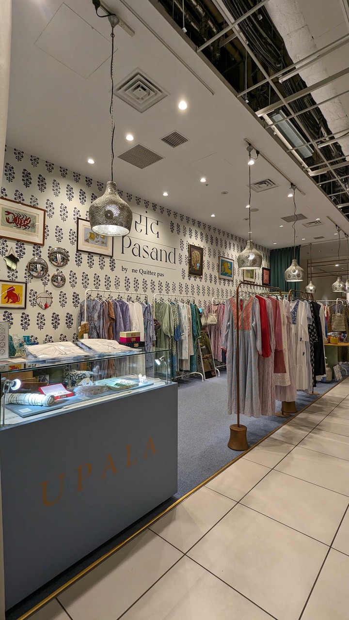 パサンドバイヌキテパのカウンターの前に色とりどりの服が掛けられたラックが並んでいます。