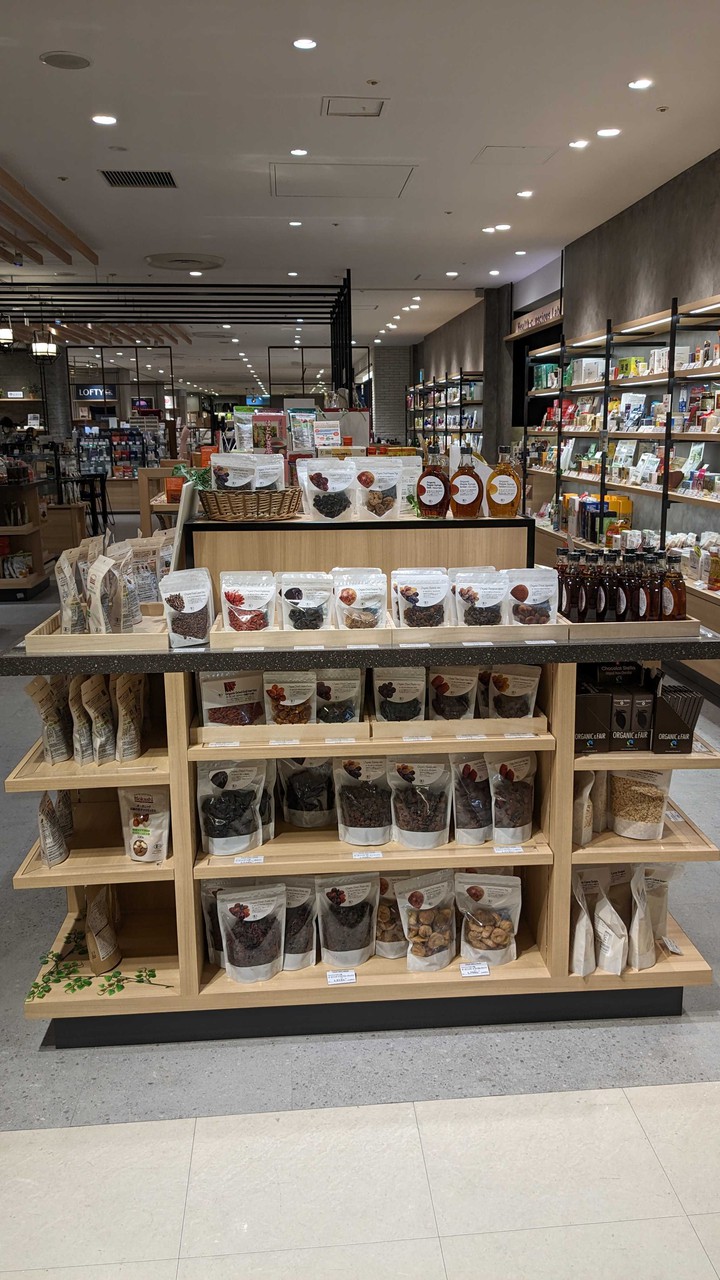 ナッツやドライフルーツ、オーガニックグラノーラが陳列されたヘルスコンシャスラボの棚。広々とした店内が清潔で整頓された雰囲気を演出しています。