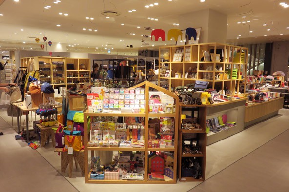 Das bitte! by Neue　梅田店の写真。木製の棚やディスプレイに、カラフルな文具、おもちゃ、ギフトアイテムが並んでいます。