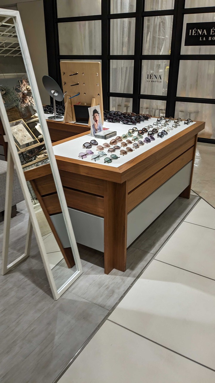 ミスシープ アイヴァンの展示テーブルには、さまざまな色と形のメガネフレームが整然とディスプレイされています。