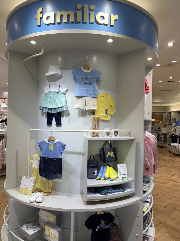 ファミリアのディスプレイに飾られた明るい色の子供服。動物モチーフのトップスや小物が展示されています。