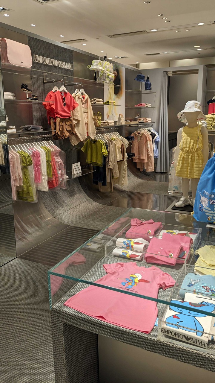 エンポリオアルマーニジュニアの店内全体を映した写真。明るい色調の子供服が並び、ブランドロゴが目立つ洗練された雰囲気です。