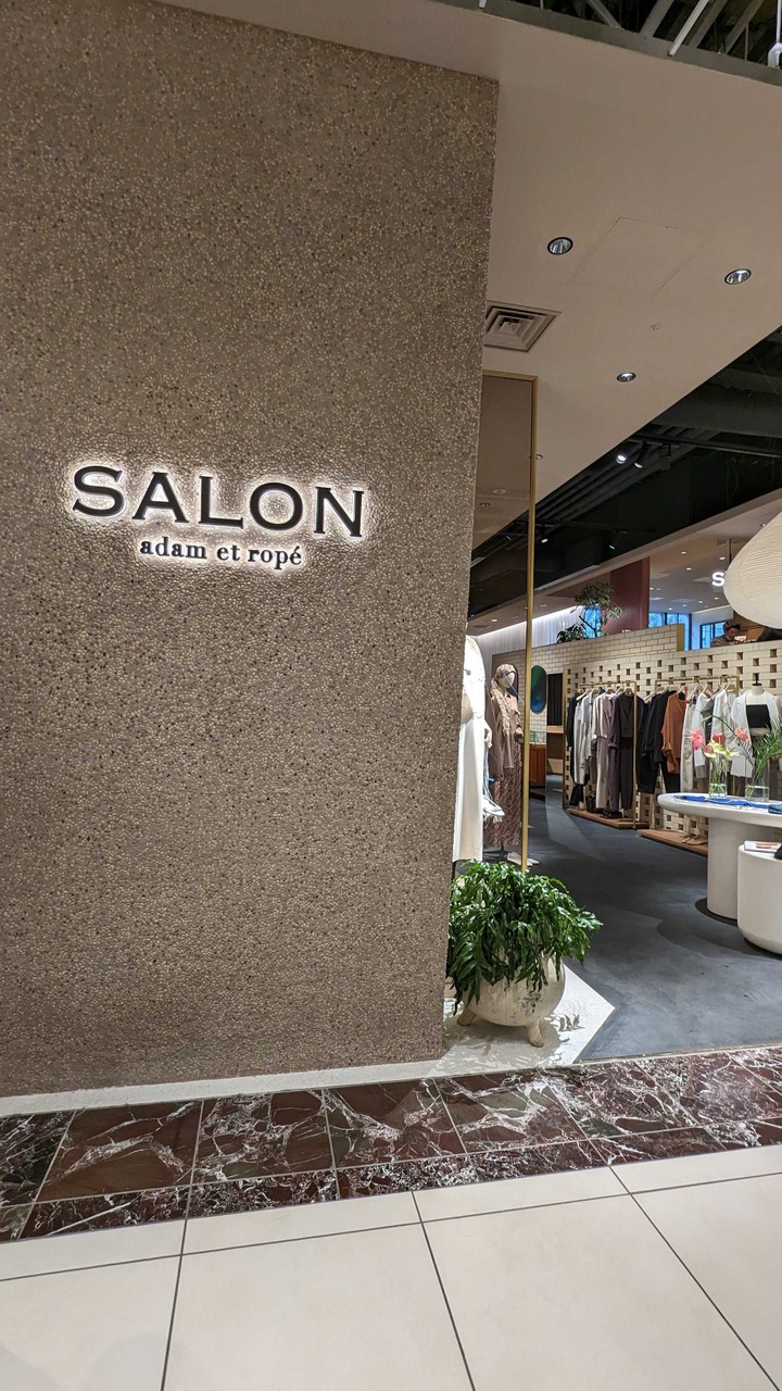 落ち着いた色合いの壁に「SALON adam et ropé」の文字が浮かぶエントランス。