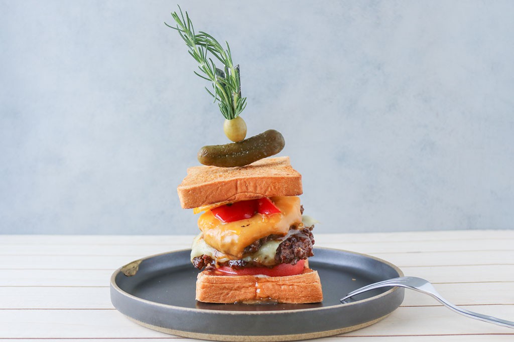 サンドイッチは牛肉100％を使用したボリュームたっぷりのジューシーな味わいのサンドイッチ画像。