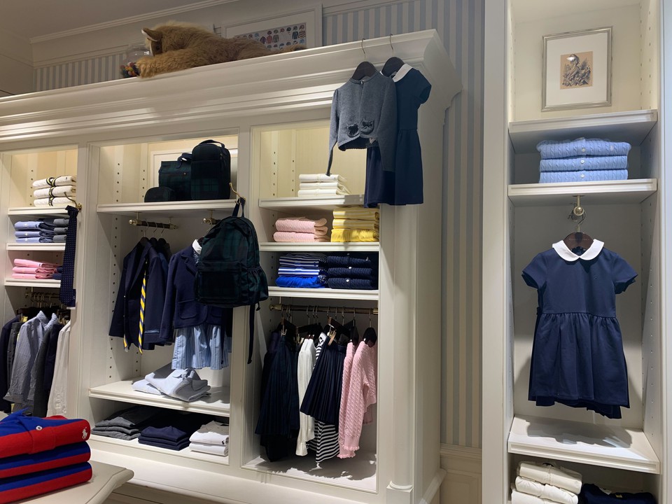 ポロラルフローレンチルドレンの店内で、上品なネイビーと白色を基調とした子供服が展示されている様子。
