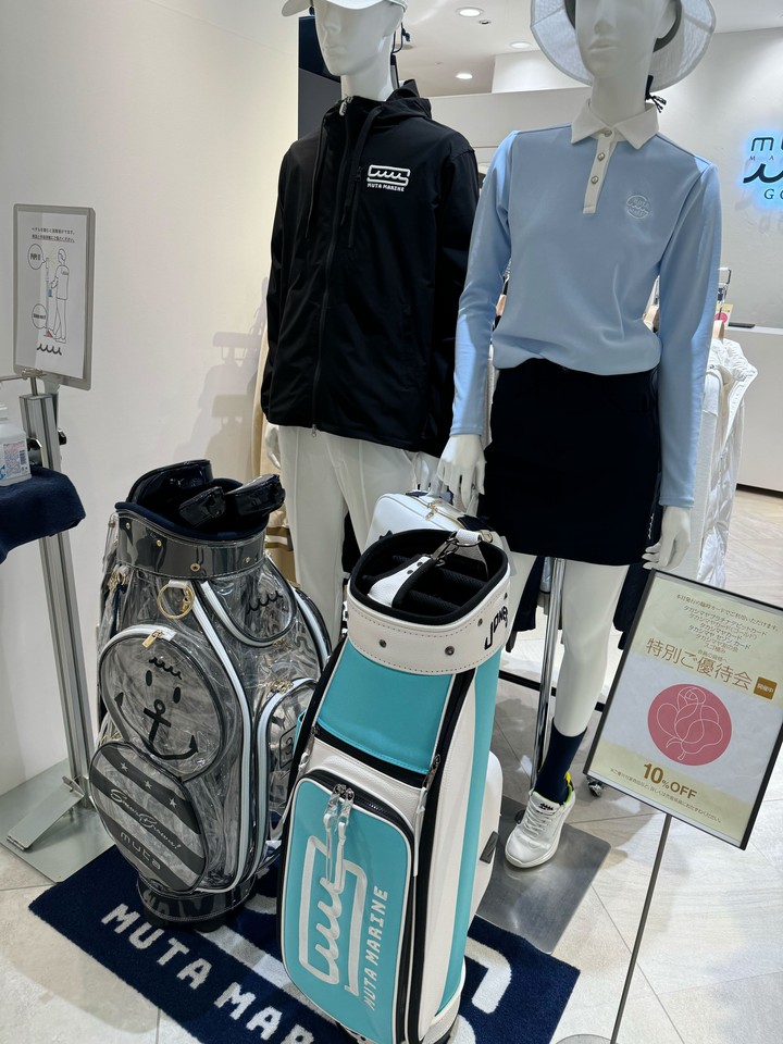 ムータマリンゴルフの店内に展示された男女マネキン。男性マネキンはブラックのジャケット、女性マネキンはライトブルーのポロシャツを着用し、それぞれゴルフバッグが隣に置かれています。
