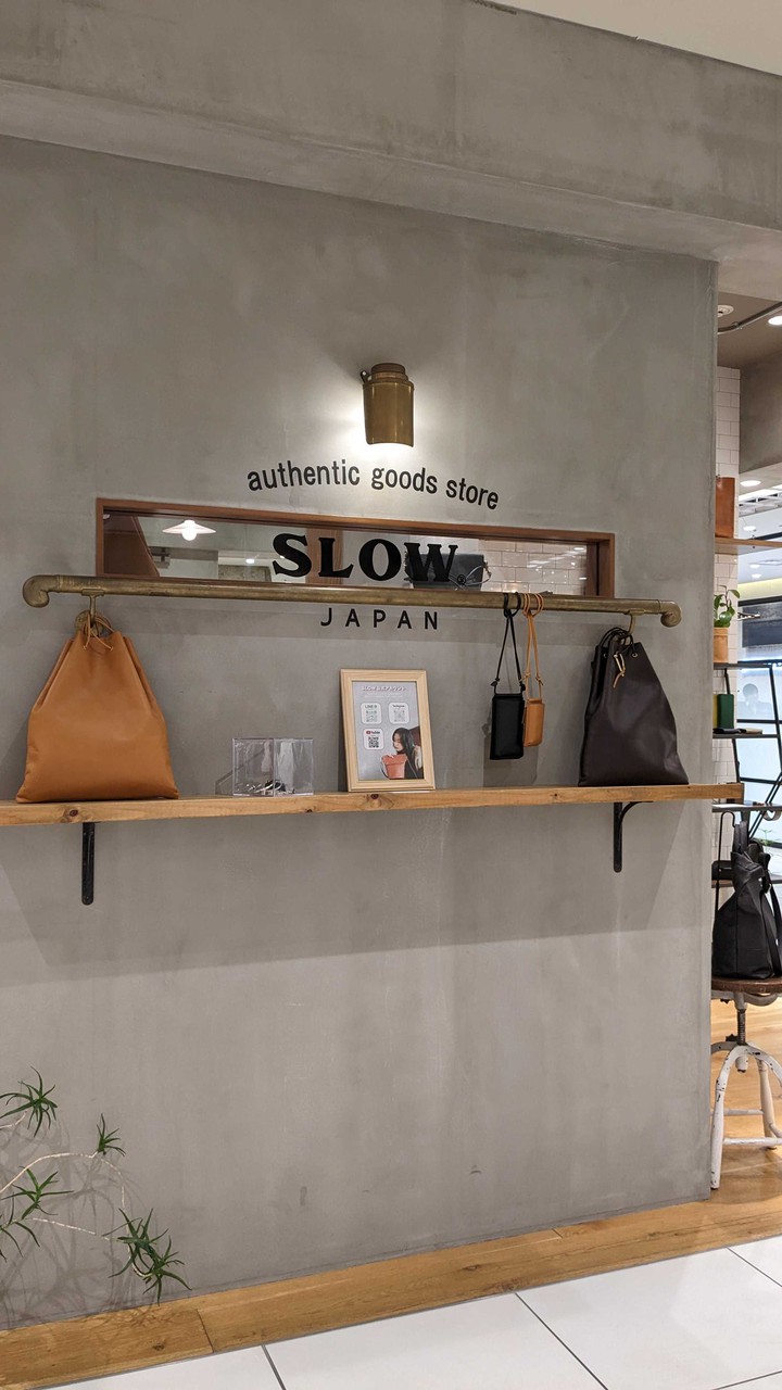 スロウ オーセンティック グッズ ストアの店内の壁に掛けられたシンプルなデザインのレザーバッグ。