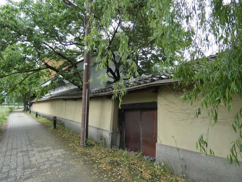 商家「茣座九」の中津川沿い塀