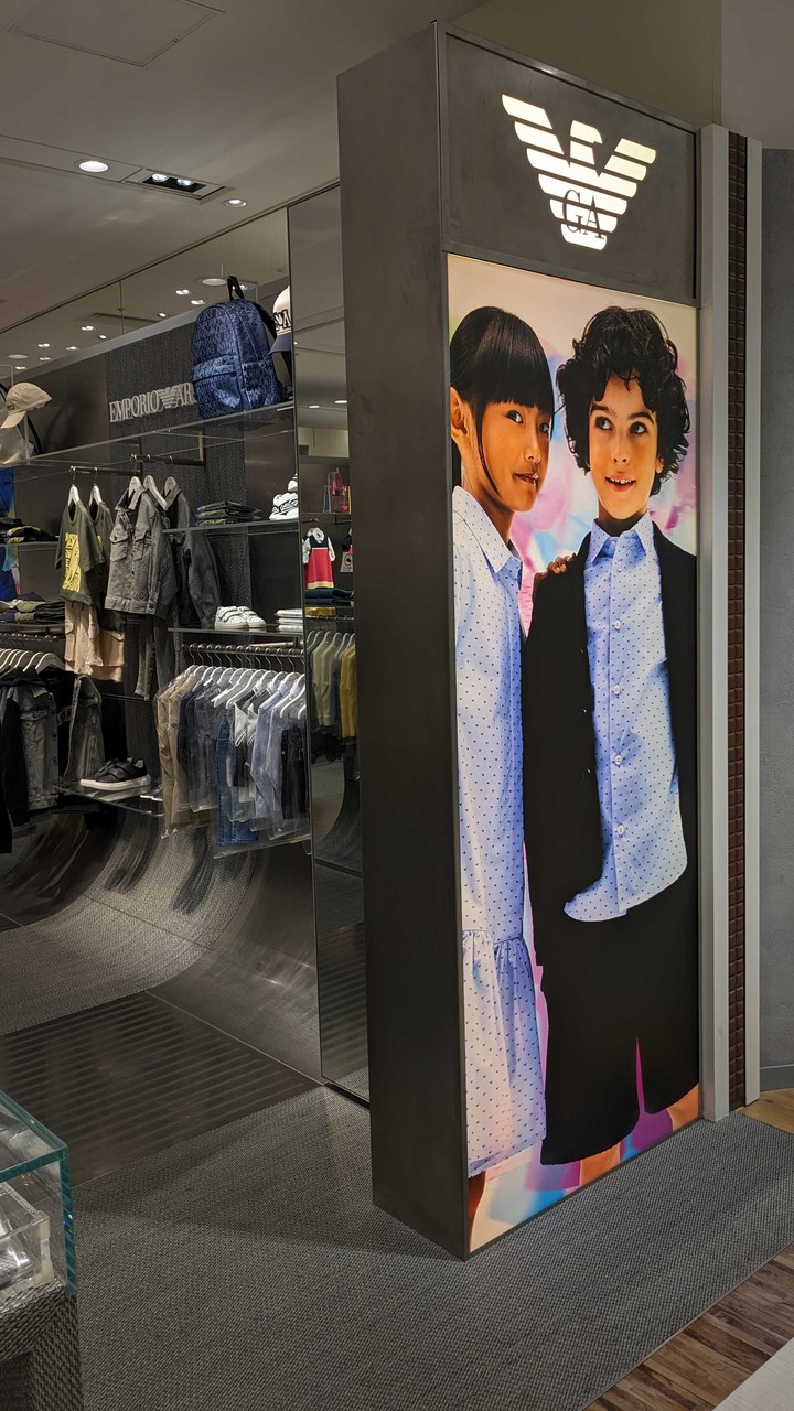 エンポリオアルマーニジュニア店舗のプロモーション用ポスター。子供モデルが現代的なブランド服を着てポーズをとっており、おしゃれな印象を与えます。