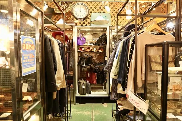 衣類コーナーの様子。洋服やアクセサリーがハンガーやガラスケースにディスプレイされています