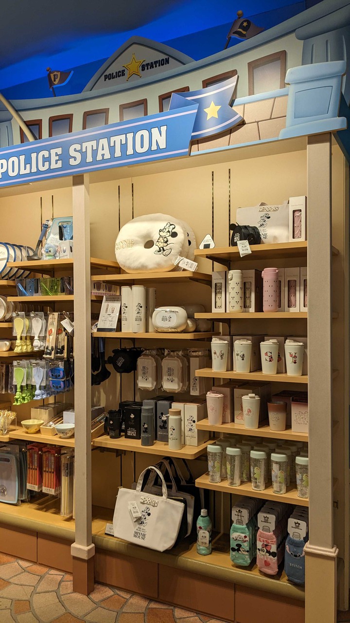 Disney storeで「POLICE STATION」とデザインされた棚の上部にミッキーとミニーのイラストがあしらわれた商品が陳列されている