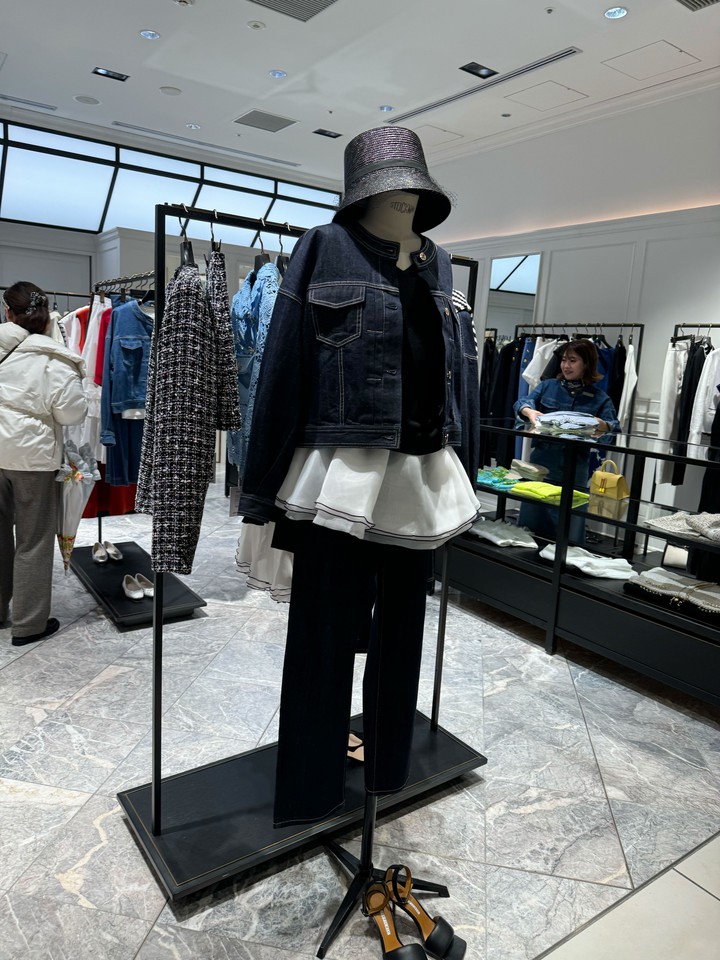 スタイリッシュなルルウィルビーの店内にデニムジャケットを羽織ったマネキンが展示されており、周囲にはさまざまな服がラックに掛けられています。