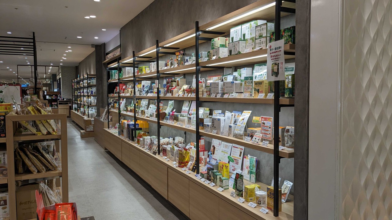 健康食品や自然派サプリメントが並んだ、明るく現代的なヘルスコンシャスラボの店内。棚にはビタミン剤や漢方、デトックスティーなどが陳列されています。