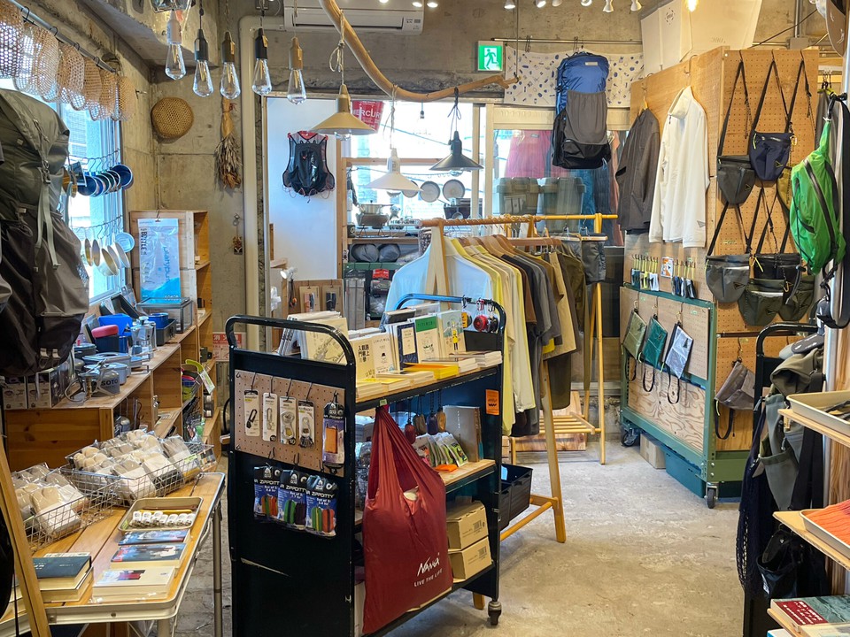 ENstyleの店内にバッグや書籍、シャツなどのアパレル、ライトなど自由にディスプレイされている