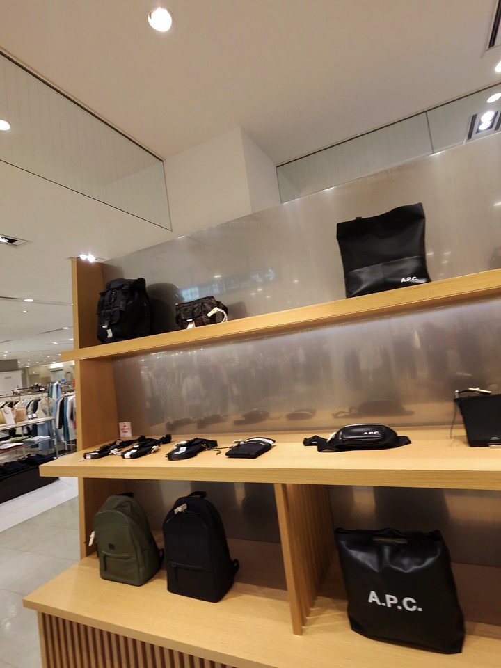 A.P.C.のバッグとアクセサリーが並ぶモダンな棚