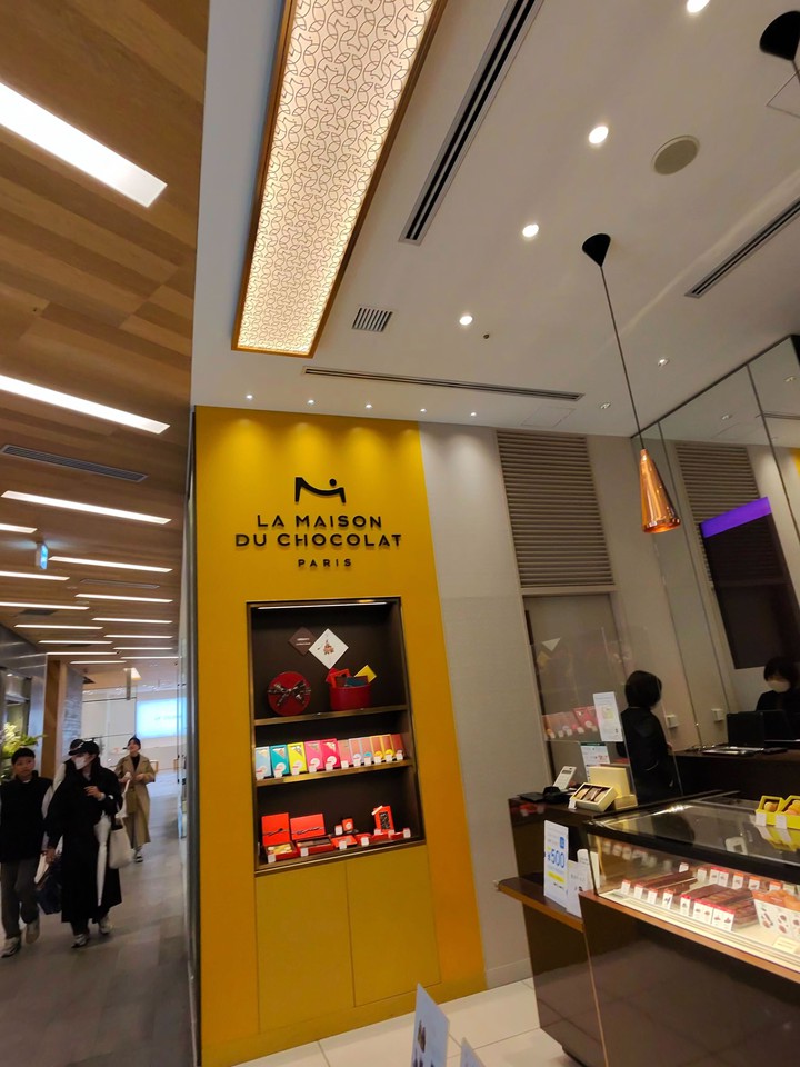 黄色い壁にロゴが映えるラメゾンデュショコラの店舗入口です。