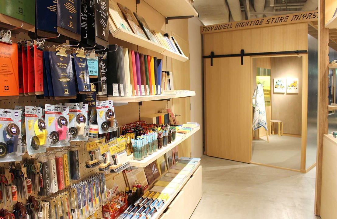 カラフルな文房具がぎっしりと並ぶ棚。クリップボード、テープライター、ノートなどがディスプレイされている