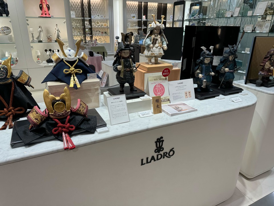 新宿高島屋 リヤドロの五月人形コレクション。色とりどりの甲冑と兜を身にまとった磁器製の人形が白い台の上に展示され、日本文化を感じさせる一角となっている